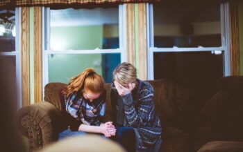 man and woman sitting on sofa in a room